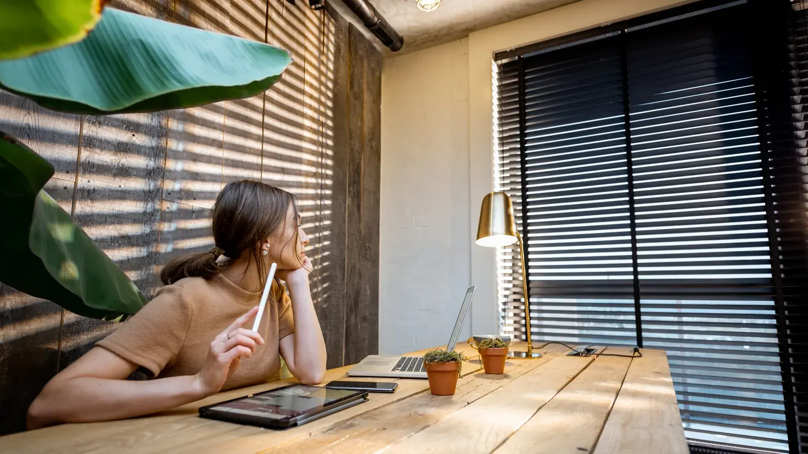 An Indonesian contractor working at a wide home desk in tropical daylight.