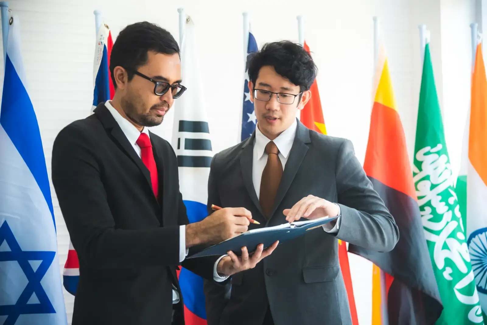 Businessmen signing agreement surrounded by world.