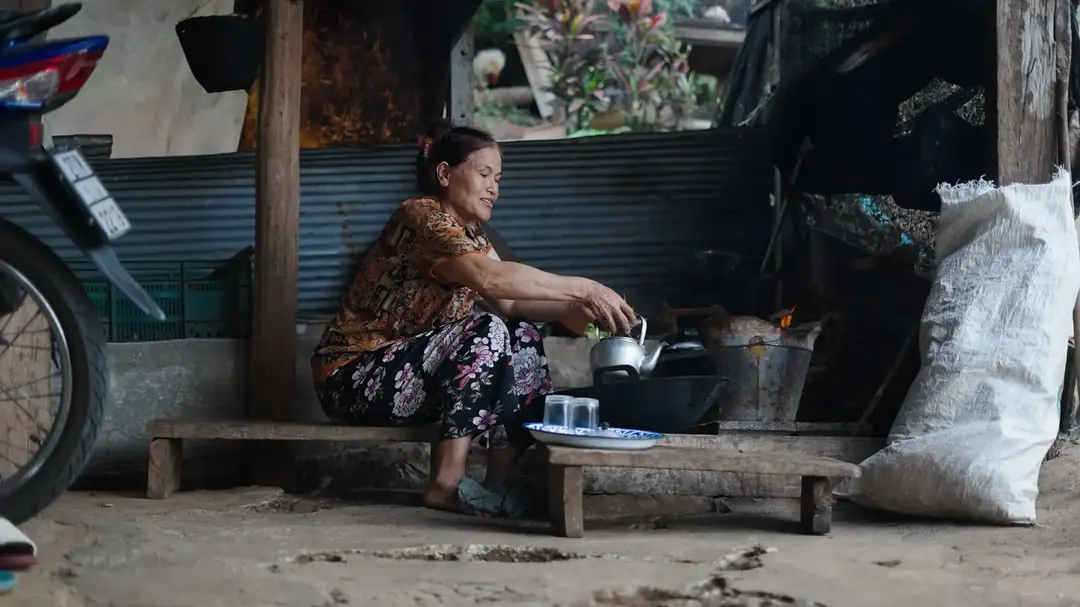 Ibu menyiapkan teh di dapur rumah.