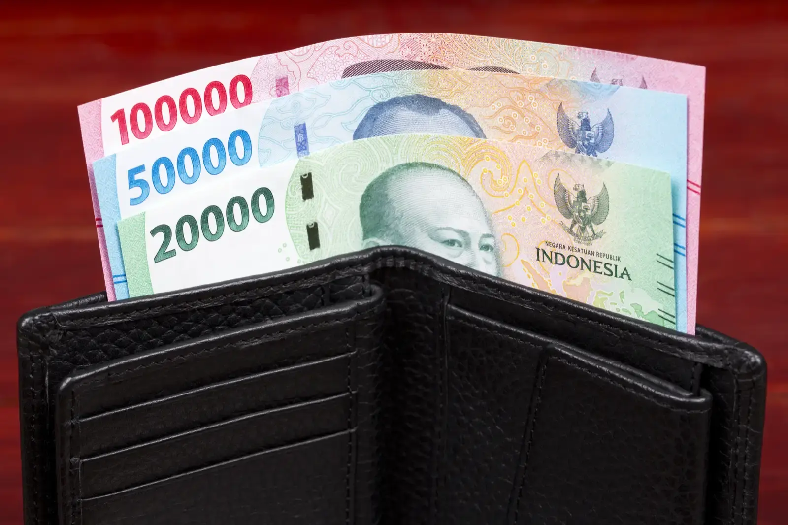 Indonesian rupiah banknotes in a black wallet.