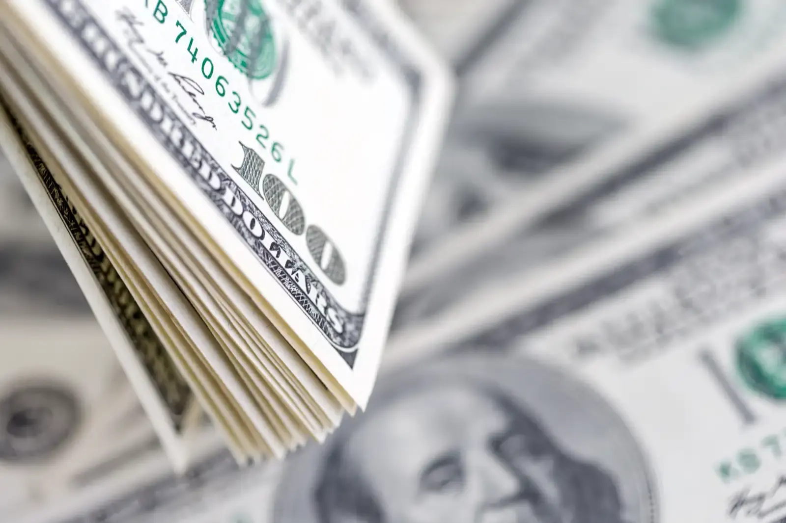 Tumpukan lembaran seratus dollar Amerika.