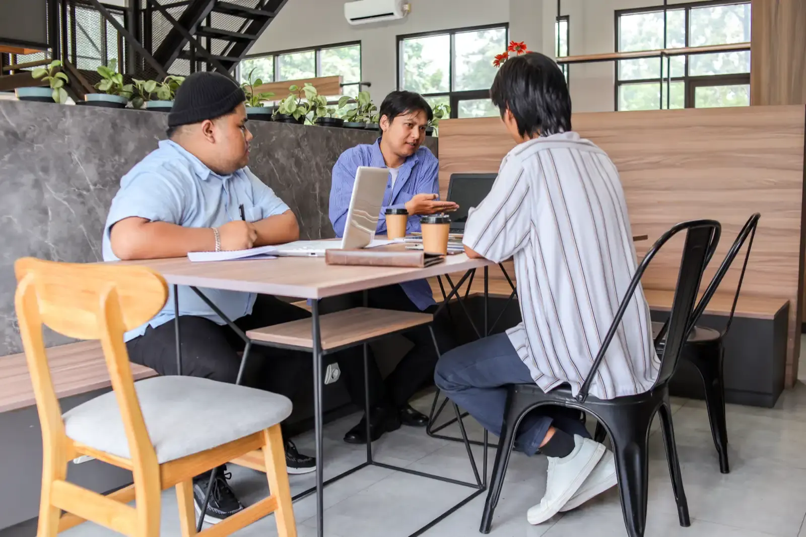 Business colleagues meeting at table with laptops.
