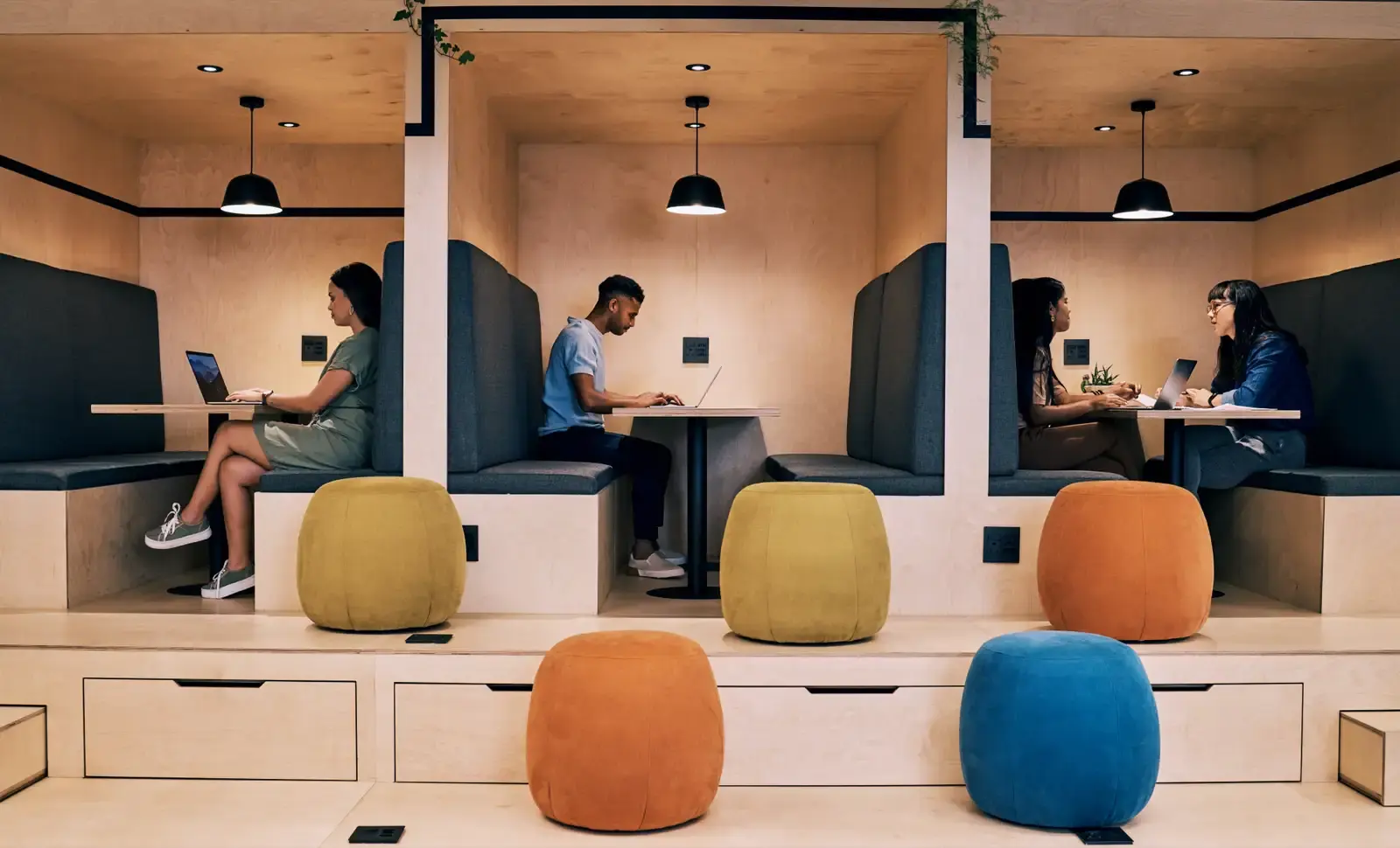 People working in modern corporate booths.