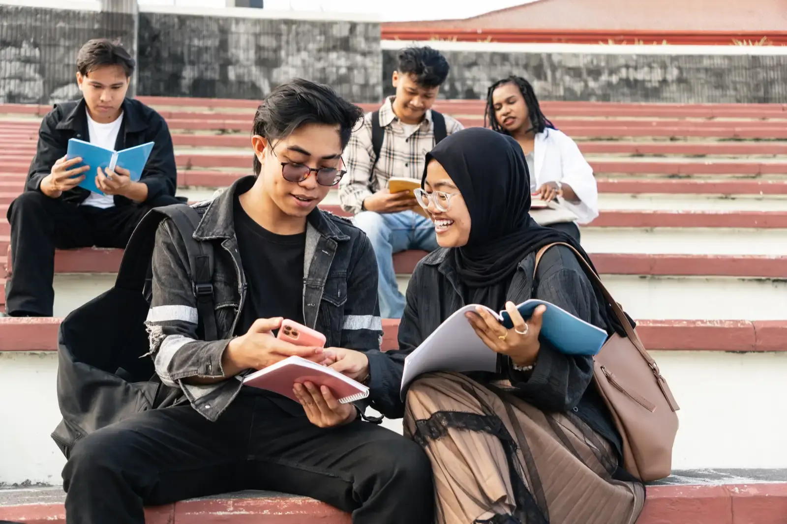 Asian university students studying together outdoo.