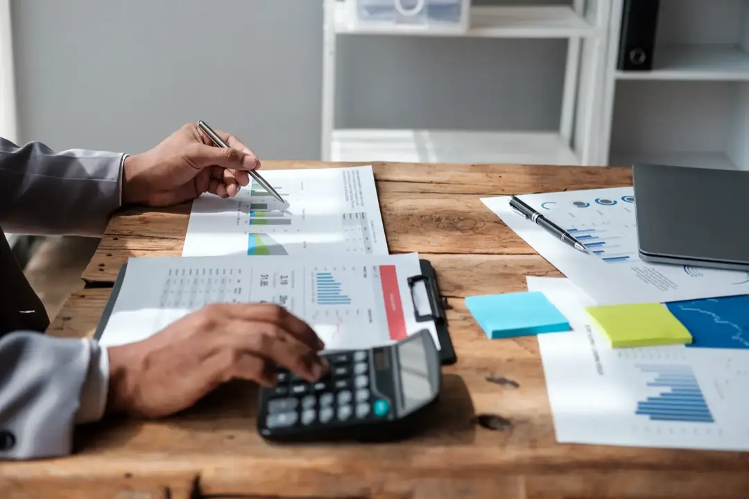 An accountant working through figures on a calculator.
