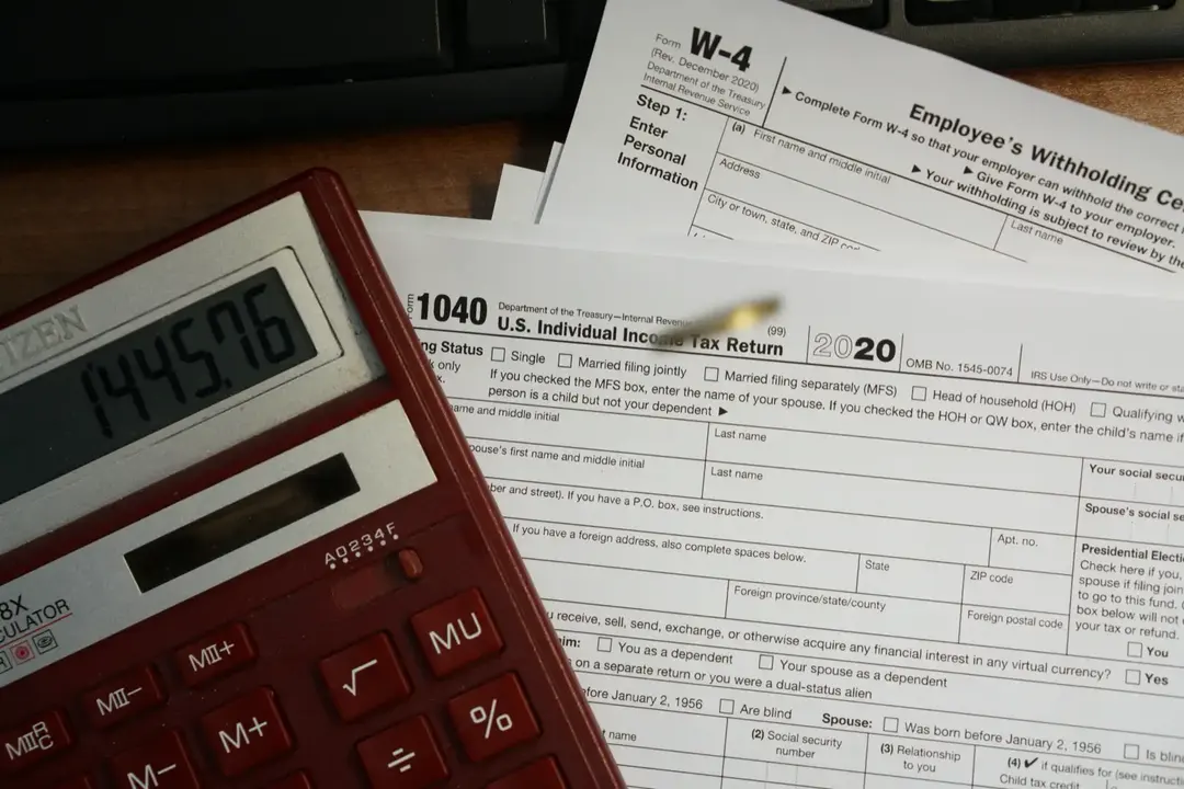 Tax forms and a calculator on a desk.