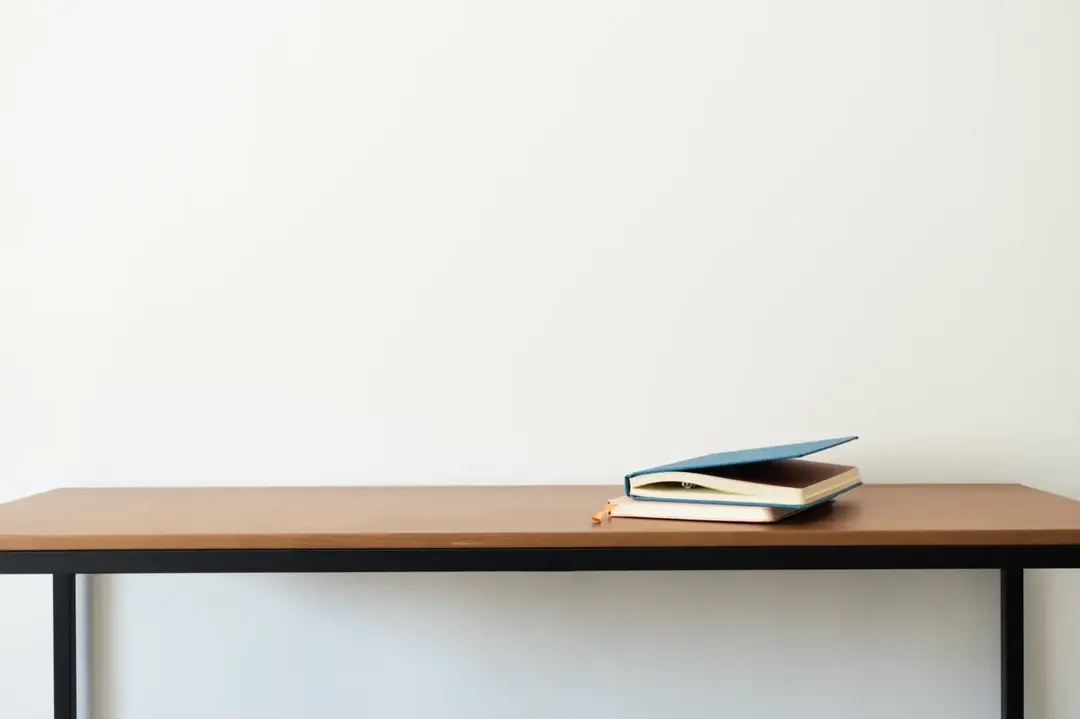 Notebooks on a minimalist wooden desk.